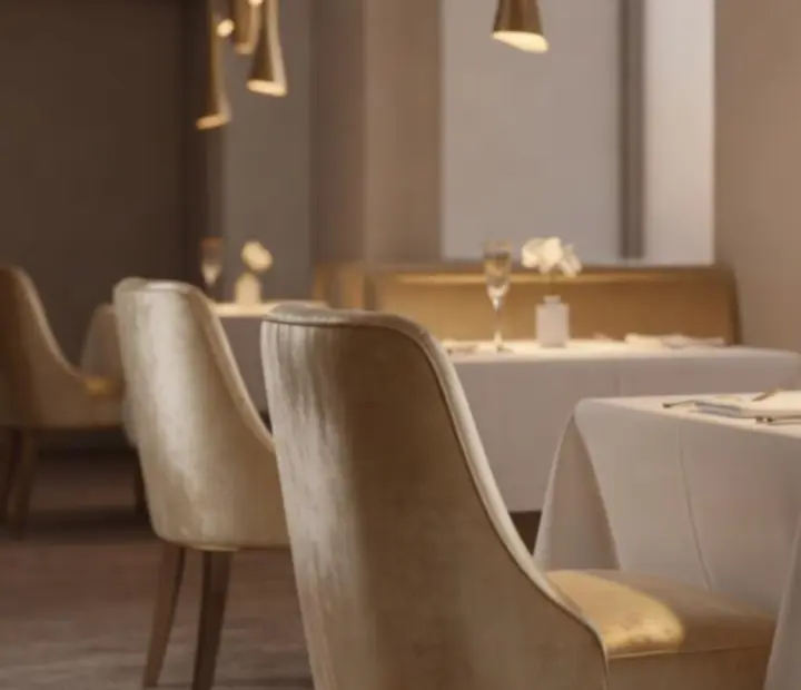 Luxury restaurant interior with soft lighting, champagne gold details and elegantly set tables.